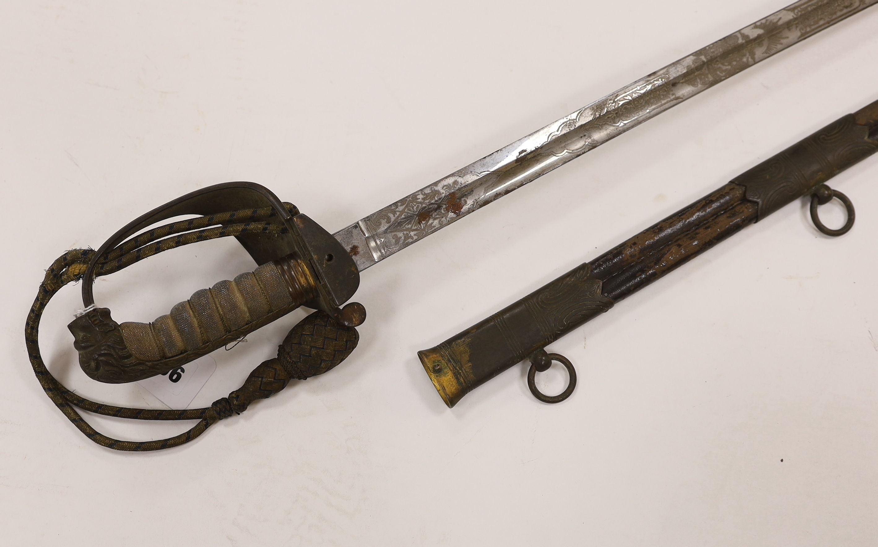 A late Victorian naval officer’s sword of the Royal Naval Reserve, regulation hilt with folding guard and bullion dress knot, in its leather scabbard with brass mounts